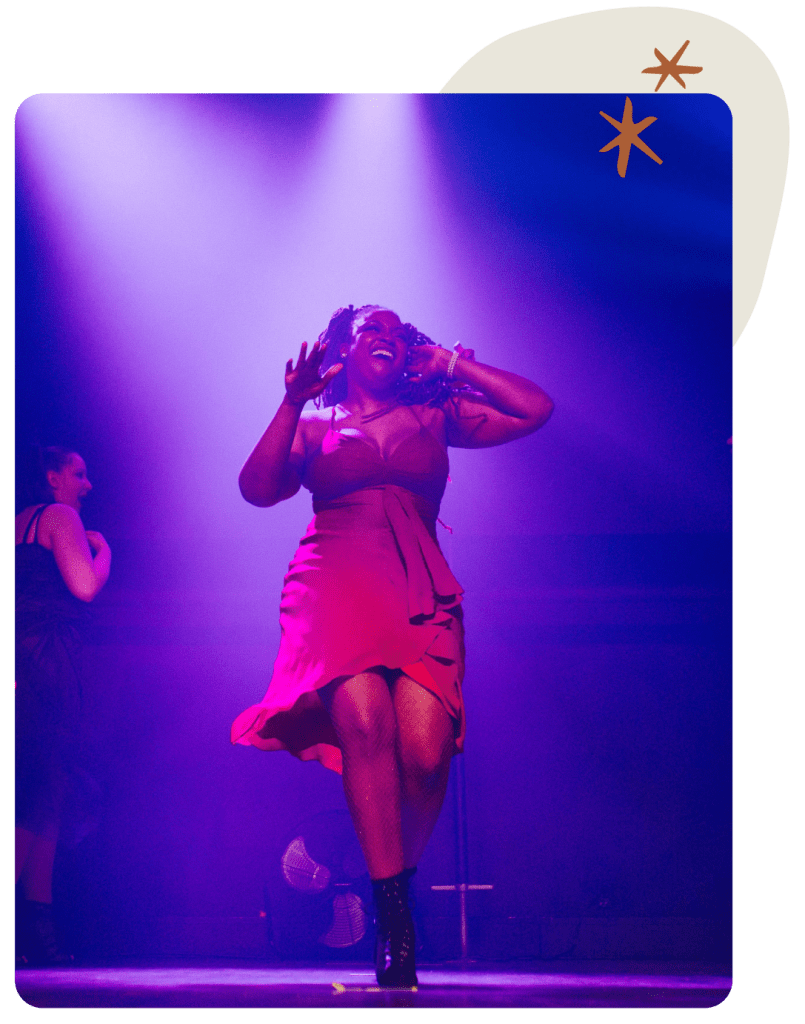 Jasmine Williams heels dancing on stage in a stunning red dress and black heels.
